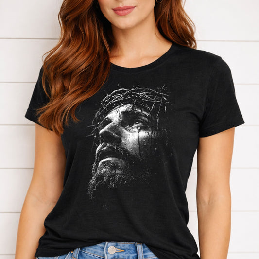 Person wearing a black t-shirt with a graphic design of a face with a crown of thorns.