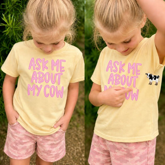 Child wearing a yellow t-shirt with pink text outdoors