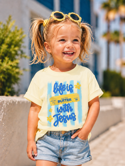 Child wearing a yellow t-shirt with a colorful design outdoors
