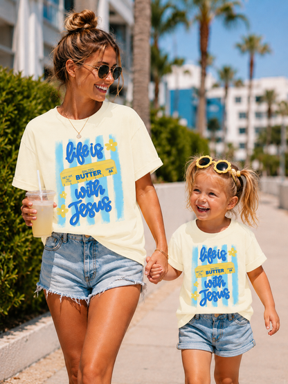 Woman and child walking together wearing matching 'Life is Butter with Jesus' t-shirts.