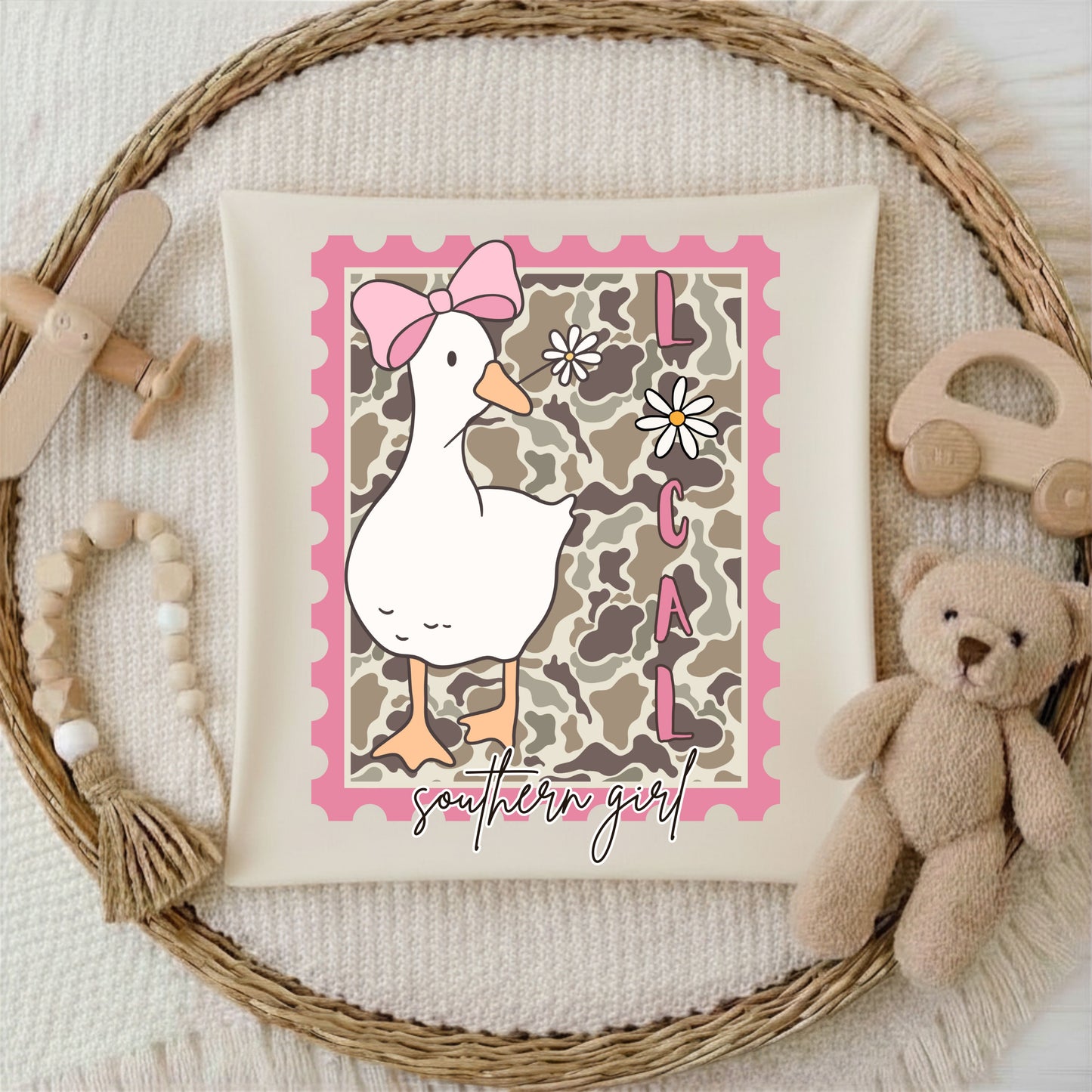 Decorative Tshirt with a duck illustration and 'southern girl' text, surrounded by toys on a textured background