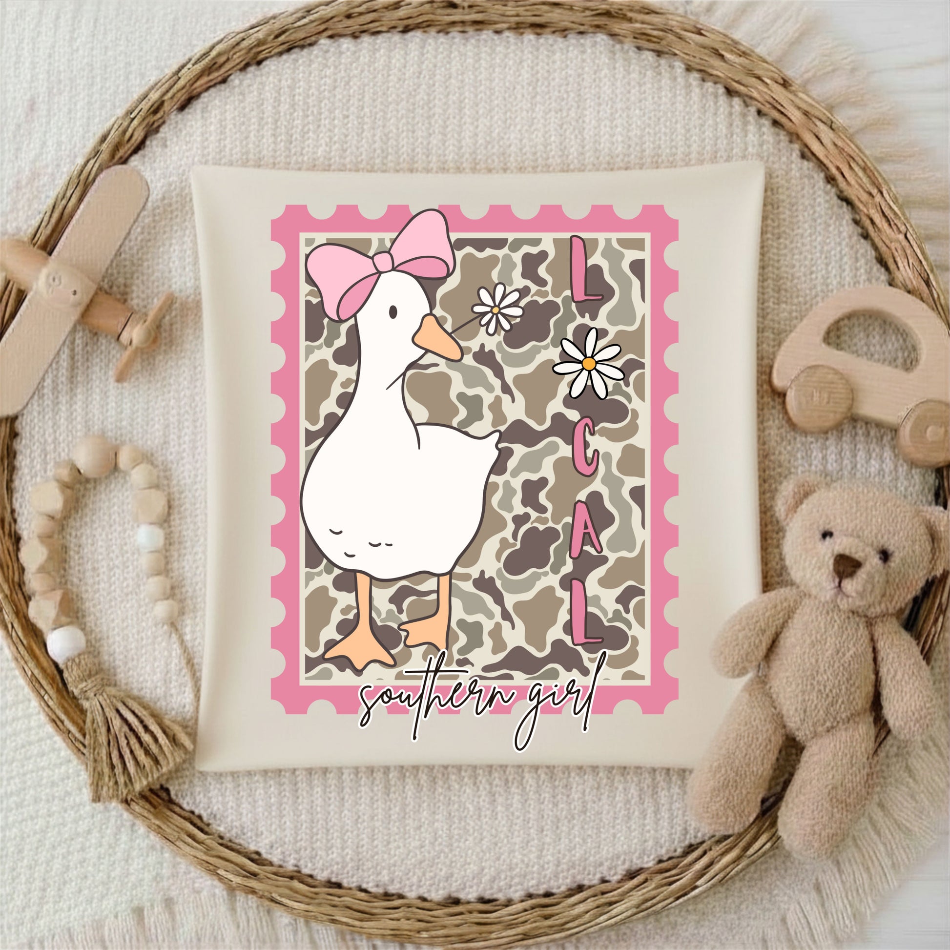 Decorative Tshirt with a duck illustration and 'southern girl' text, surrounded by toys on a textured background