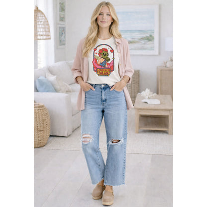Woman wearing a graphic t-shirt and jeans in a living room setting
