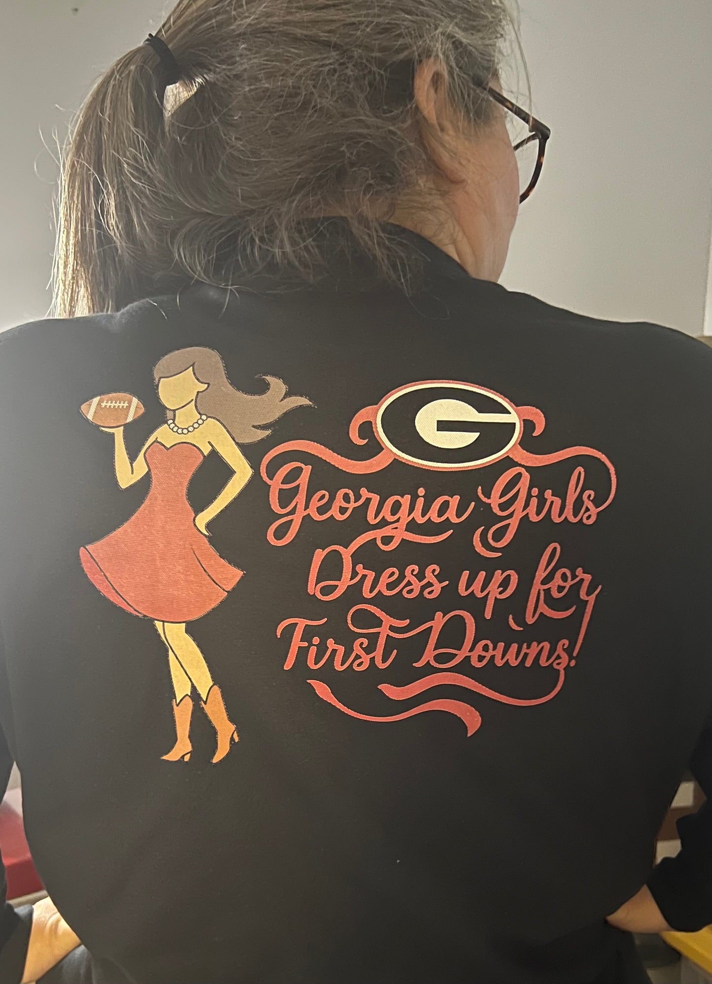 Person wearing a black shirt with a graphic and text on the back