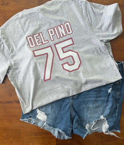 Gray t-shirt with 'DEL PINO 75' text and denim shorts on a wooden surface