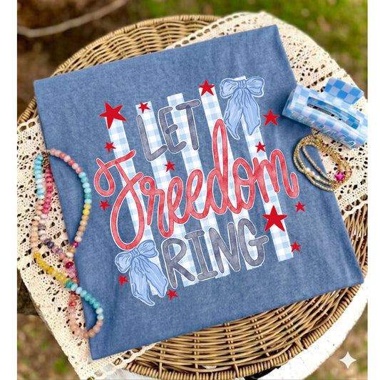 Blue t-shirt with 'Let Freedom Ring' text on a woven surface with accessories.