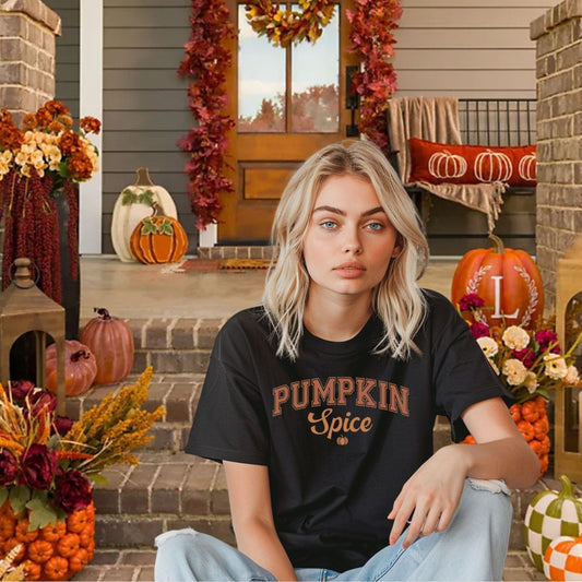 Black | Woman wearing Pumpkin Spice varsity and script font T-shirt sitting on a fall decorated front porch