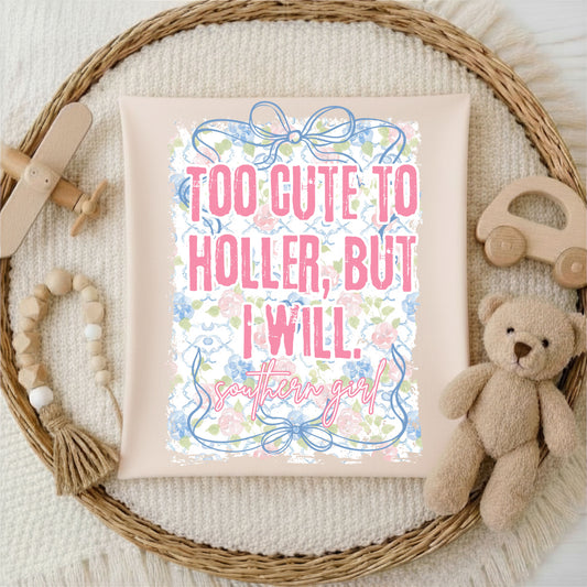 T-shirt with decorative text and floral elements on a textured surface with toys.