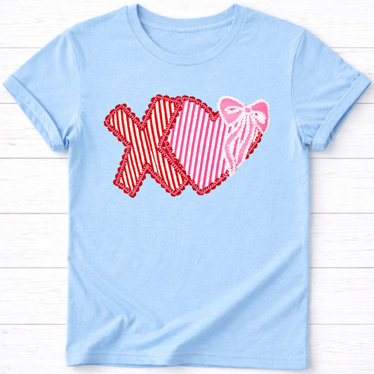 Light blue t-shirt with a red and pink graphic design on a wooden surface