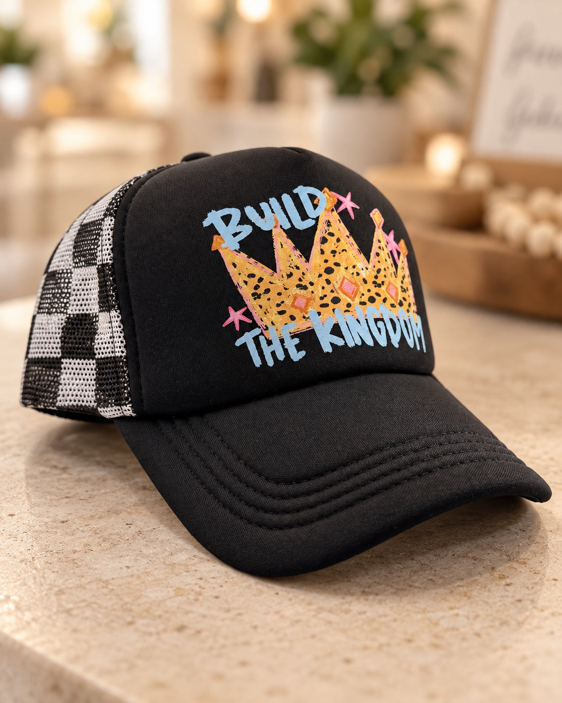 Build the Kingdom black foam trucker hat with leopard crown blue lettering pink stars and checked mesh
