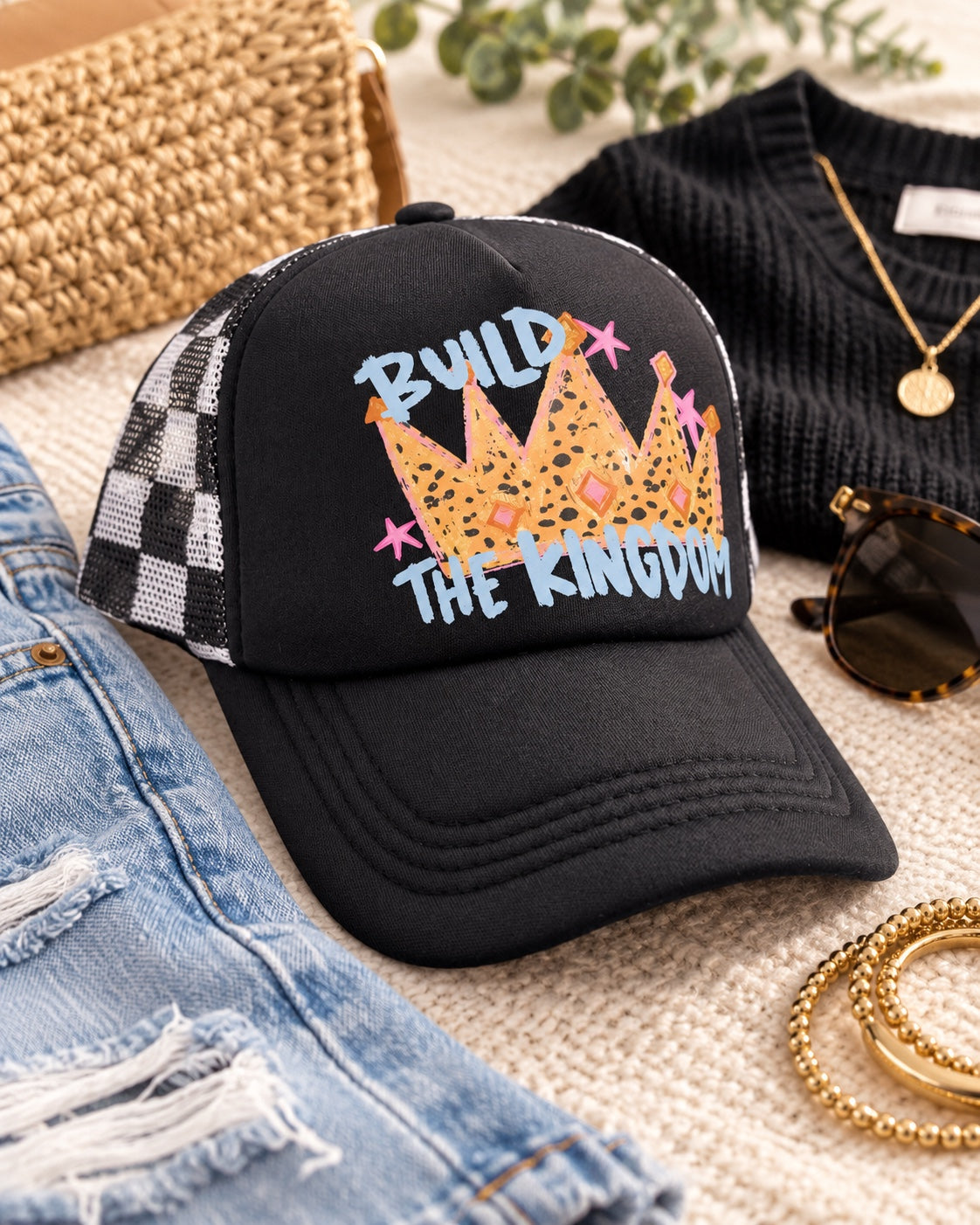 Build the Kingdom hat styled with knit top denim and accessories showing black white checker mesh