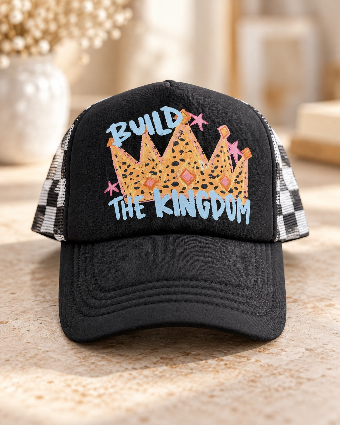 Front of Build the Kingdom leopard-print crown graphic on black foam front trucker hat