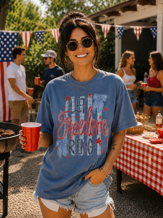 Woman wearing a 'Let Freedom Ring' t-shirt at a casual outdoor gathering.