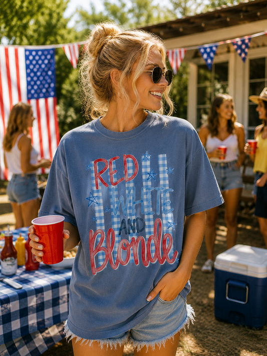 Woman wearing a blue t-shirt with 'Red, White & Blonde' text at a casual outdoor gathering.